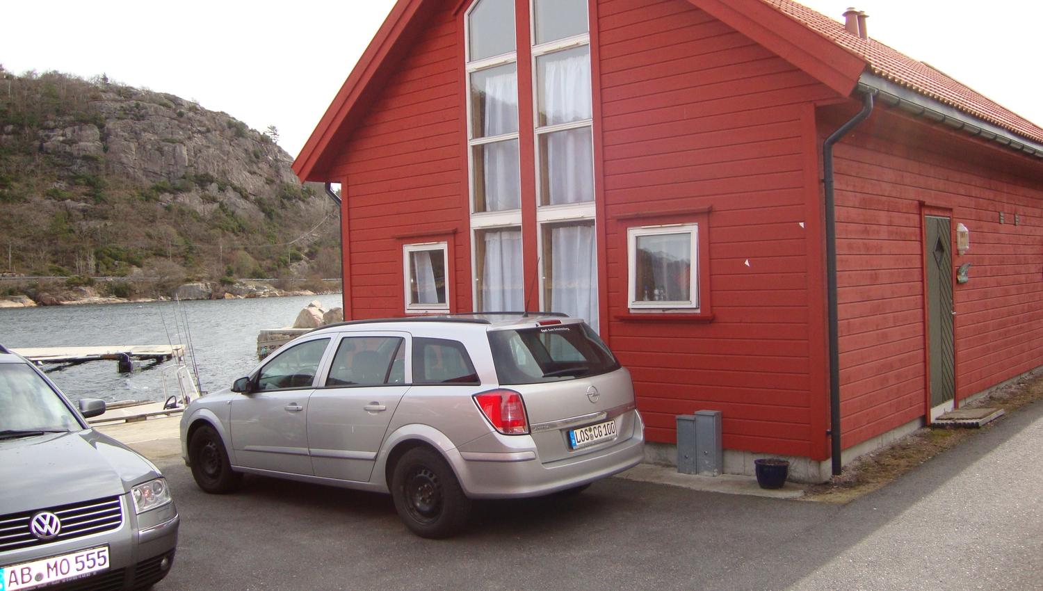 Rødt hytte med to biler parkert vedsidenav