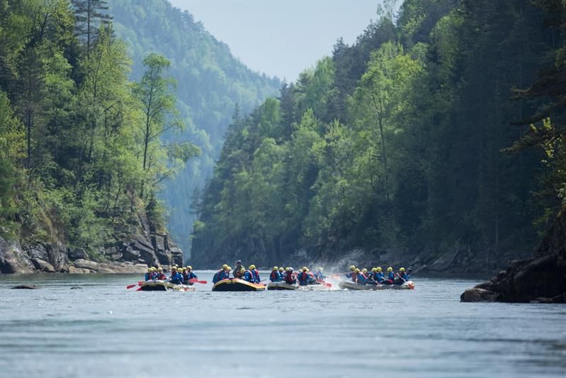 4 grupper med raftingflåter leker i vannet