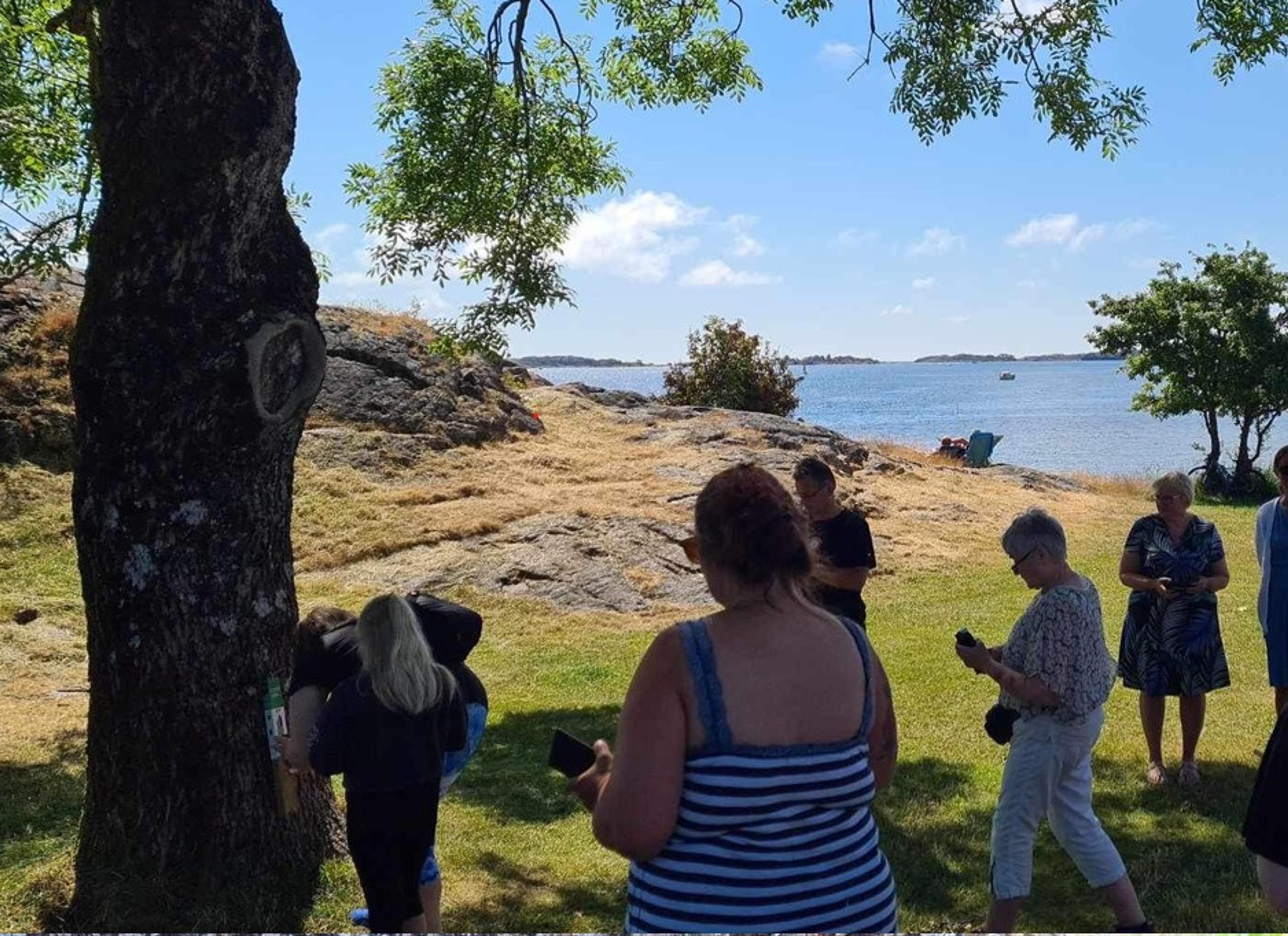 Folk ute i naturen ved siden av stolpen