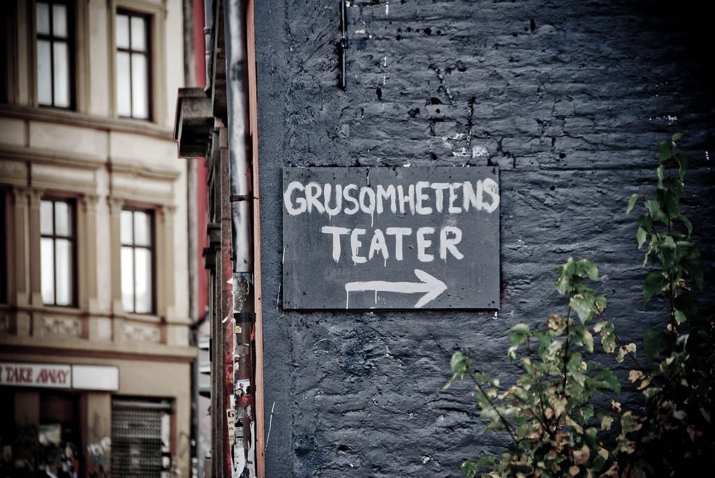Svart murvegg med skilt til Grusomhetens teater.