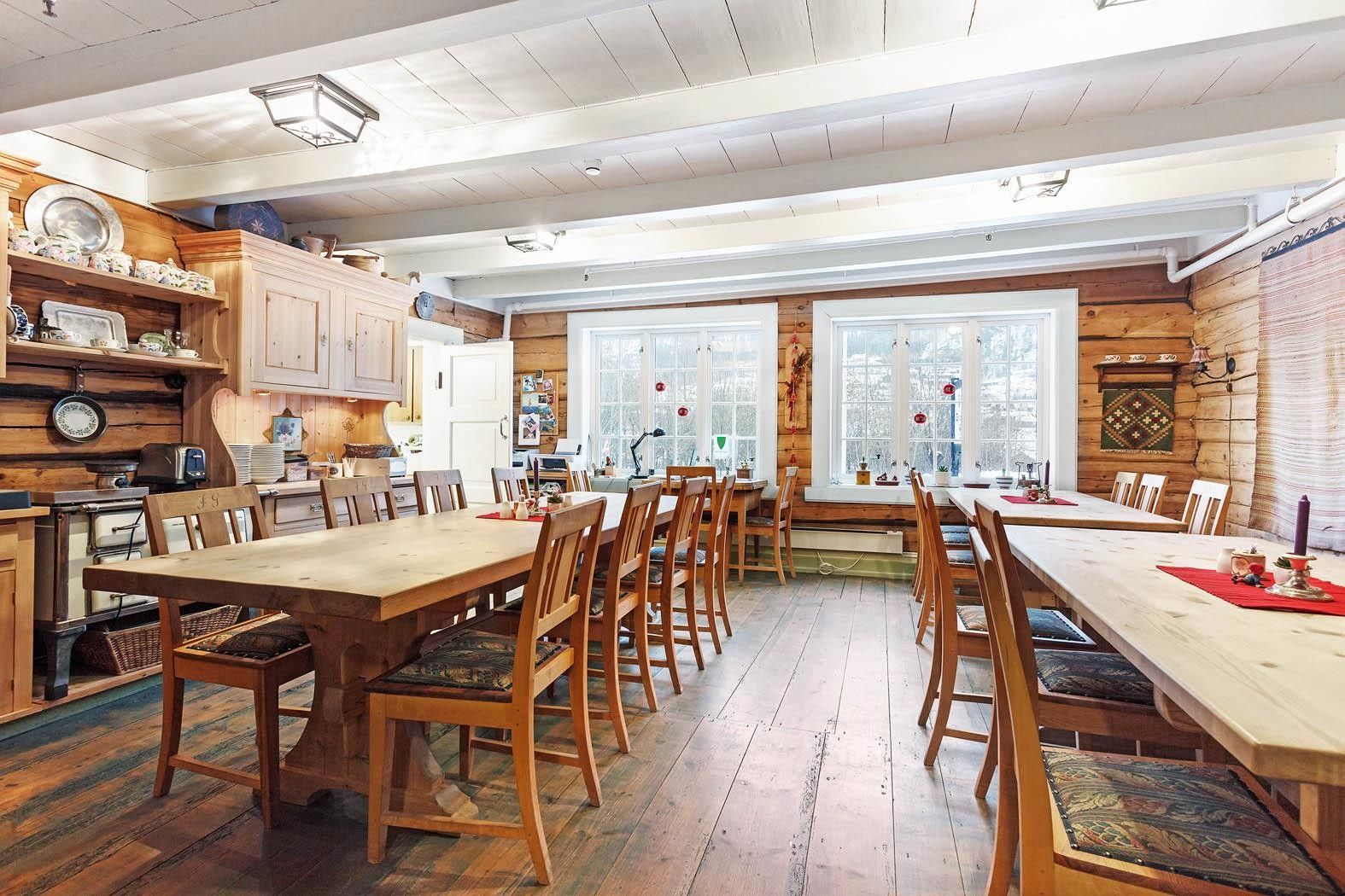 Tradisjonell matsal med tømmerveggar og langbord på Jaunsen Gjestgjevarstad i Hardanger.