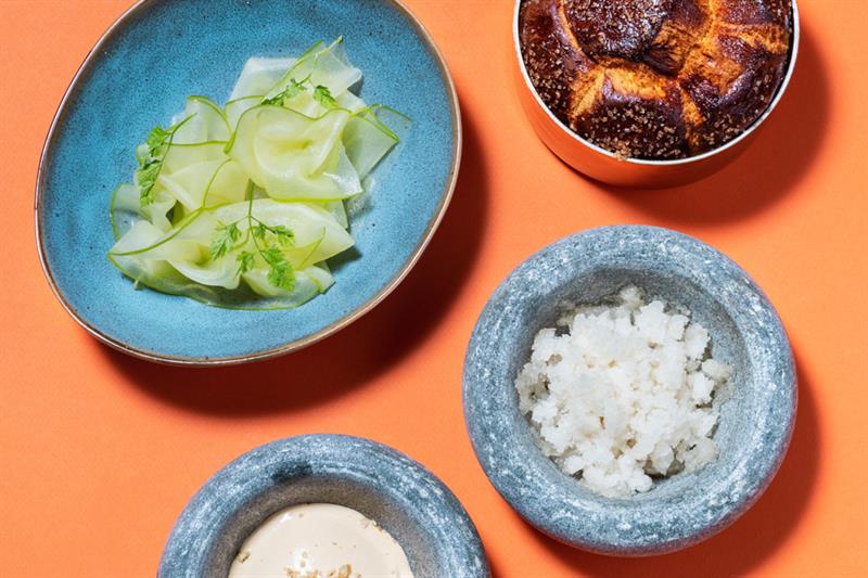 Detail photo of dishes in small bowls on an orange background.
