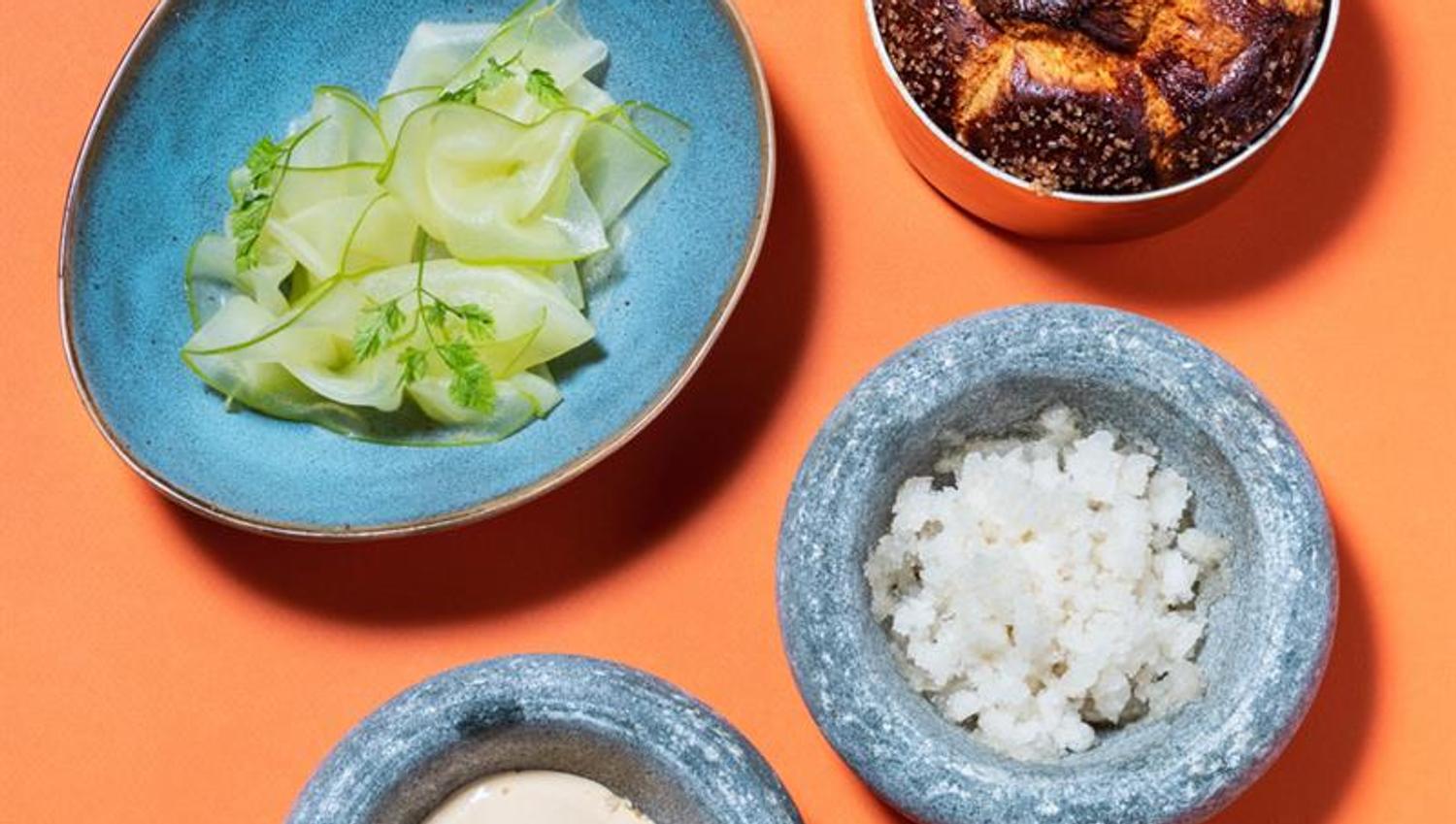 Detail photo of dishes in small bowls on an orange background.