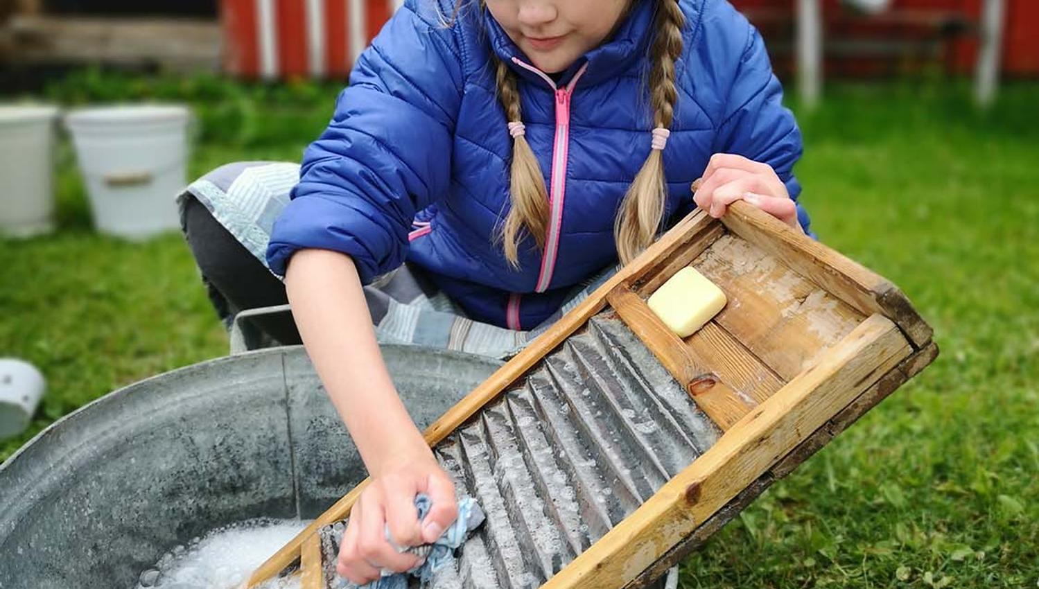 Jente vasker klær som i gamle dager