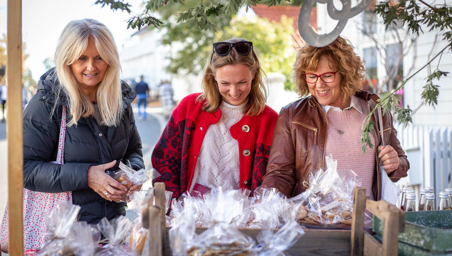 tre damer som smiler