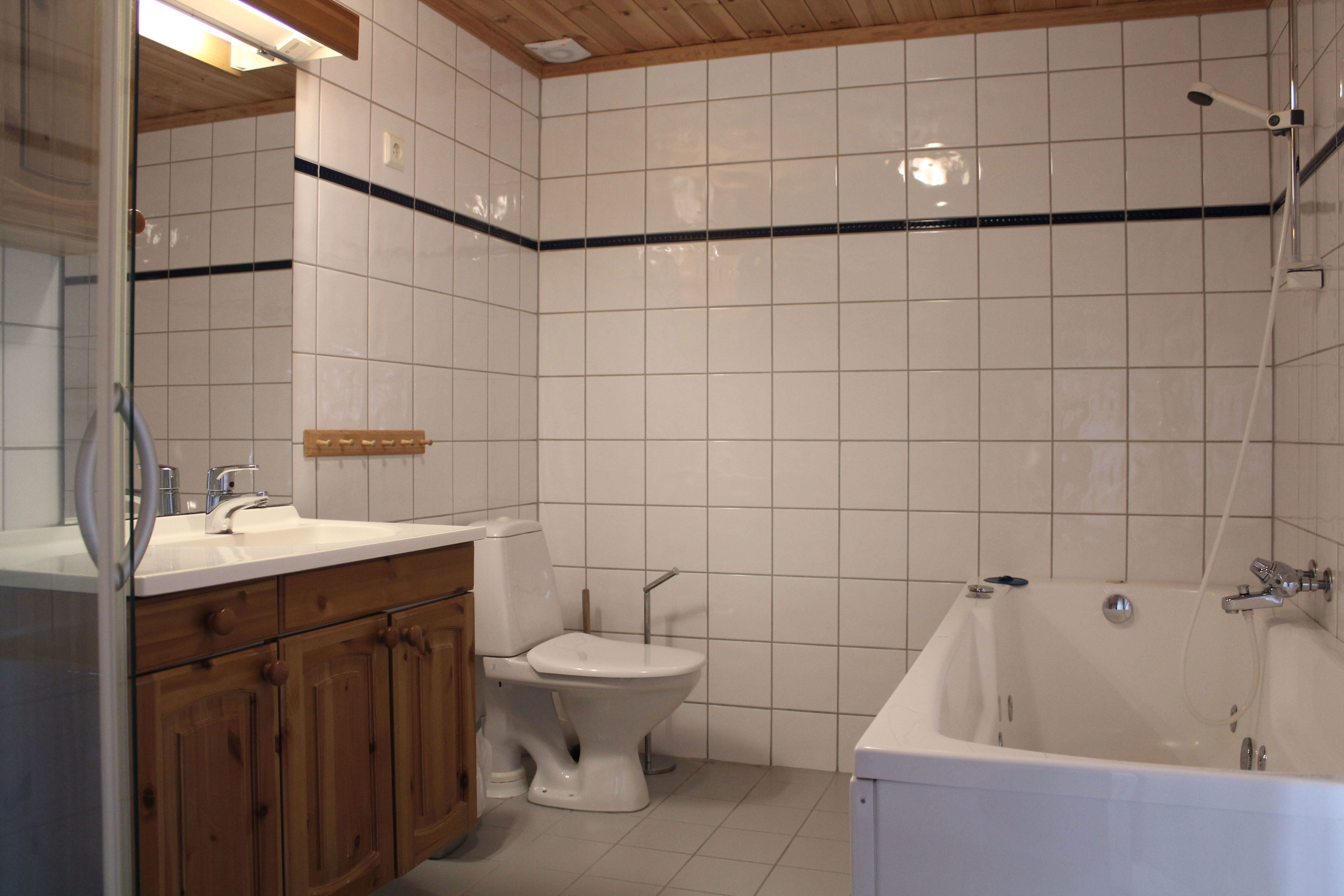 A bathroom with bathtub and toilet.