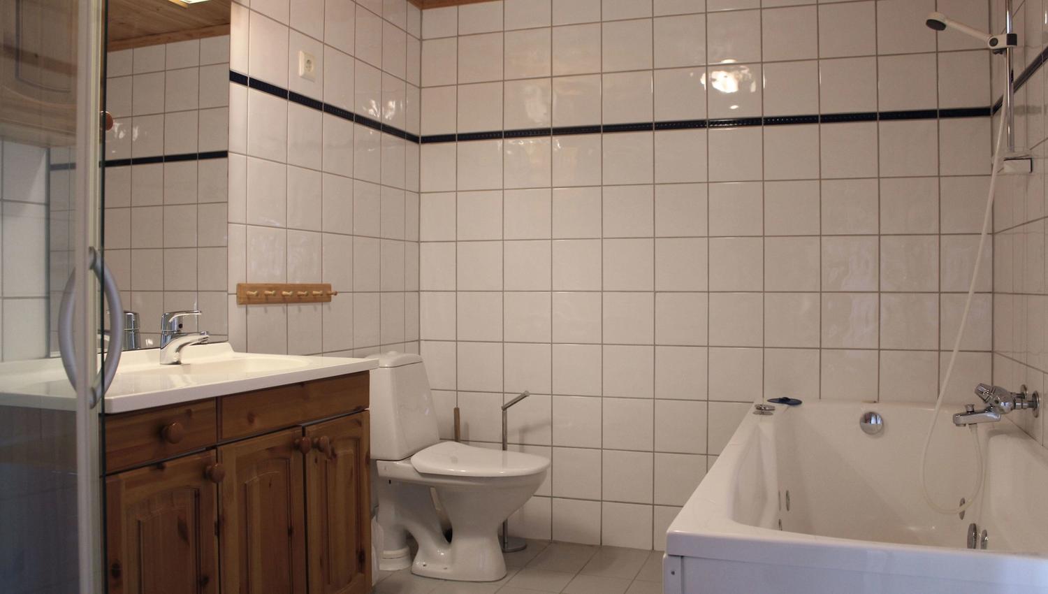 A bathroom with bathtub and toilet.