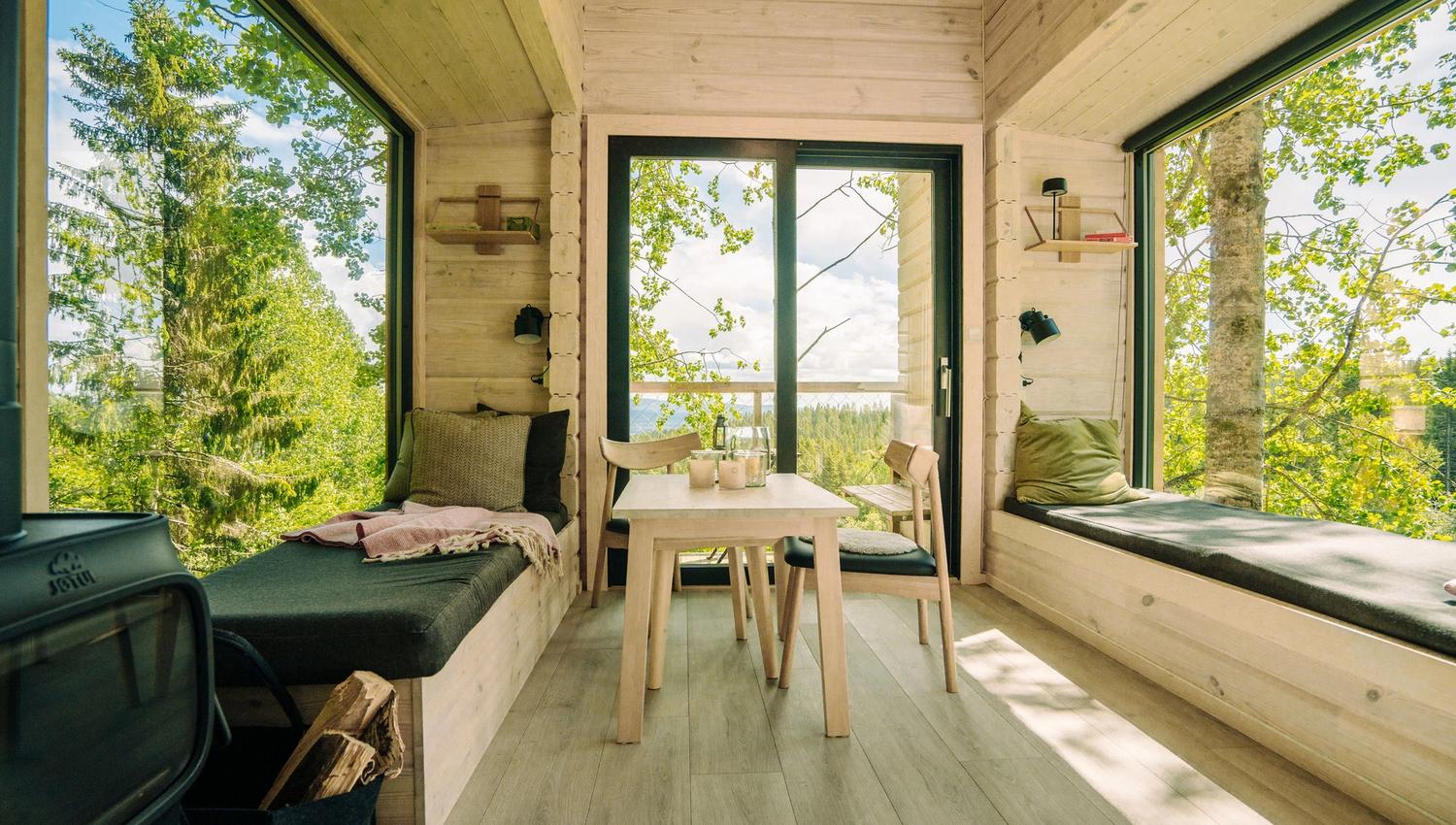 2 bed and a table in front of big windows