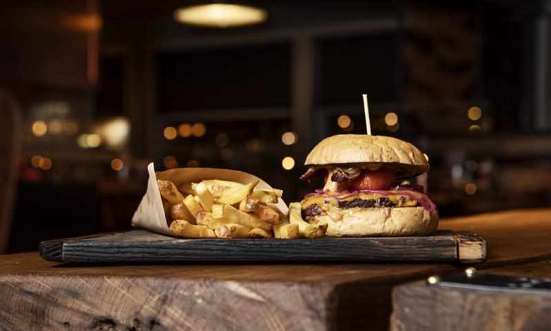 A burger with chips served on a table