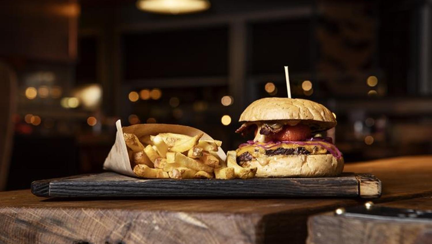 A burger with chips served on a table