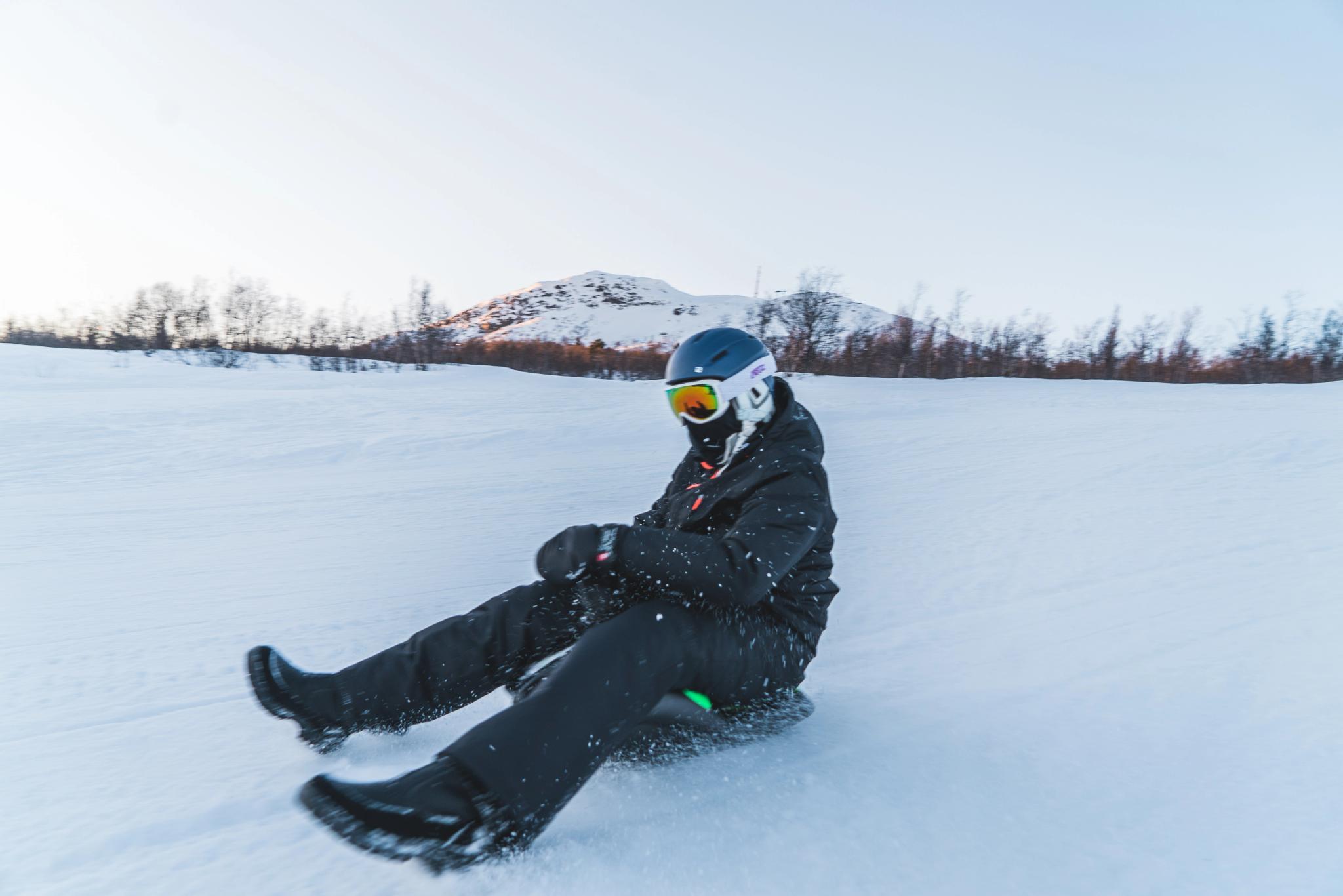 Person with helmet and goggles sledding down the alpine slope, photo