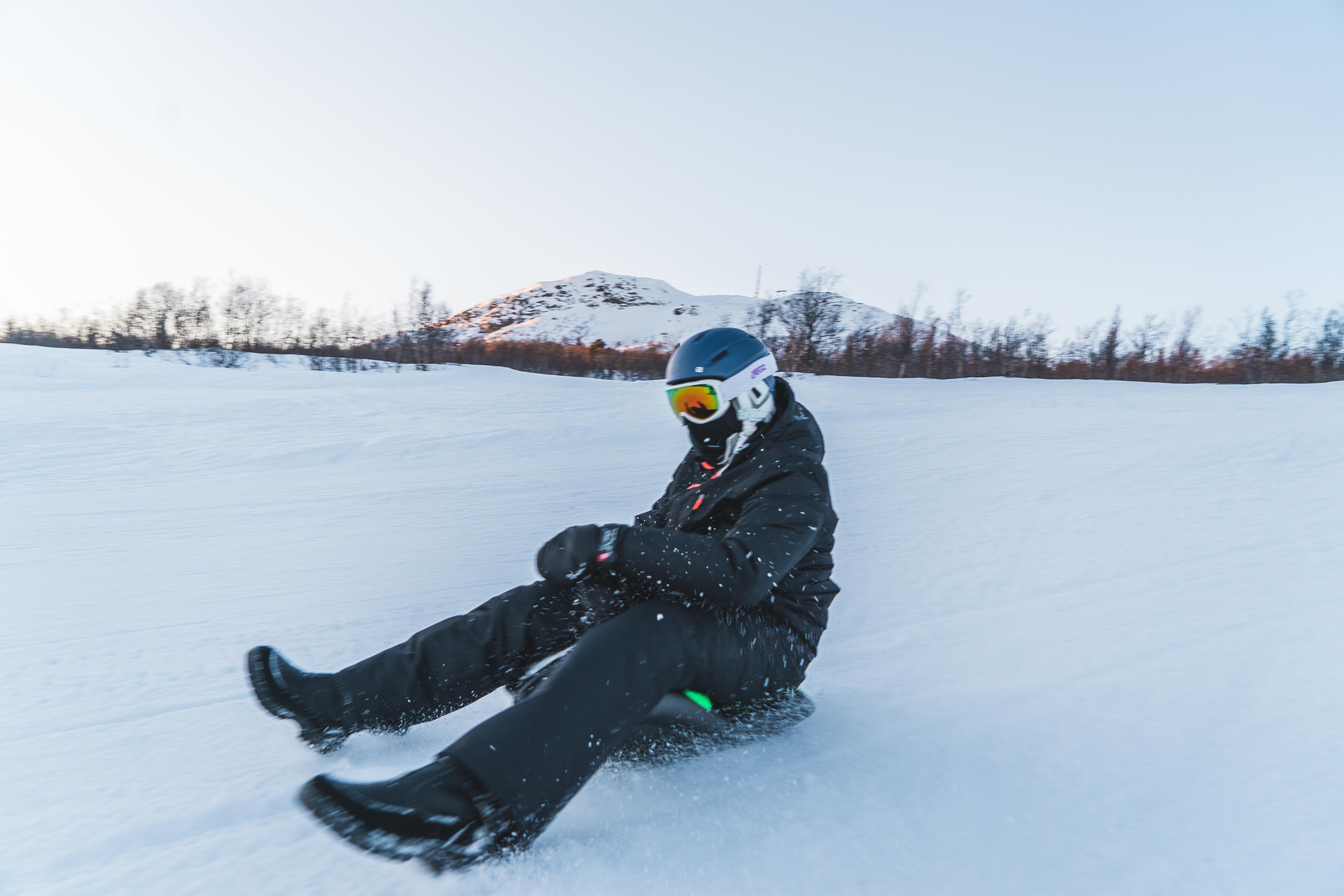 Person with helmet and goggles sledding down the alpine slope, photo
