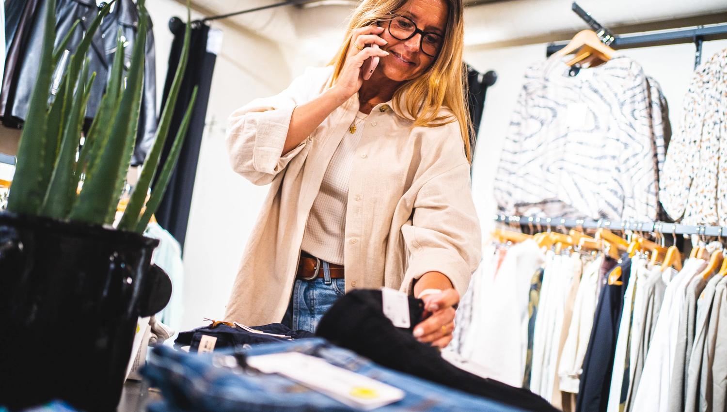 woman looking at pants in a store