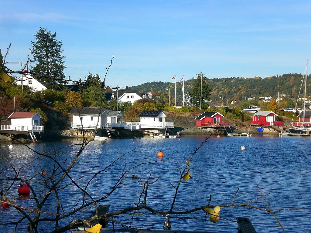 badehus i vannkanten, blå himmel og fjorden