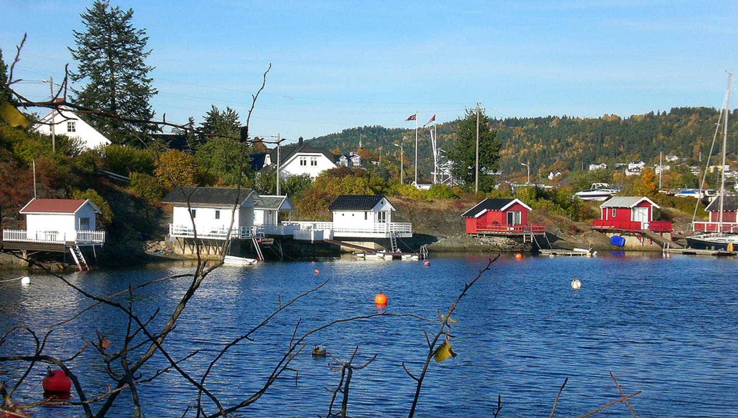 badehus i vannkanten, blå himmel og fjorden