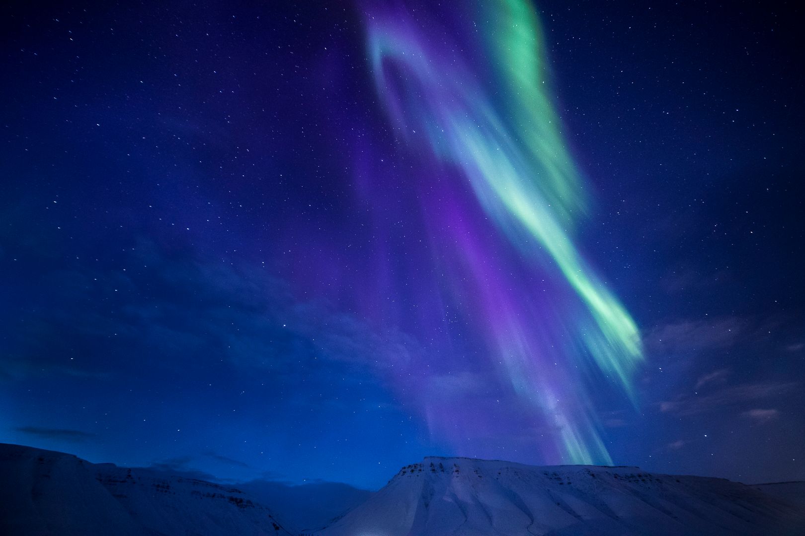 Nordlys som skinner over fjell