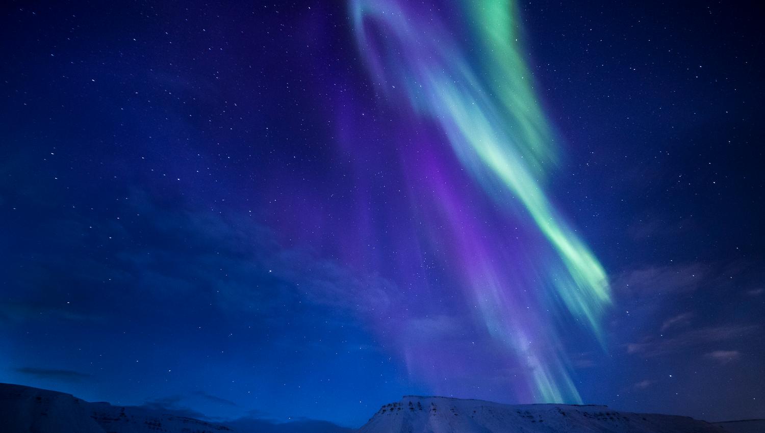 Nordlys som skinner over fjell