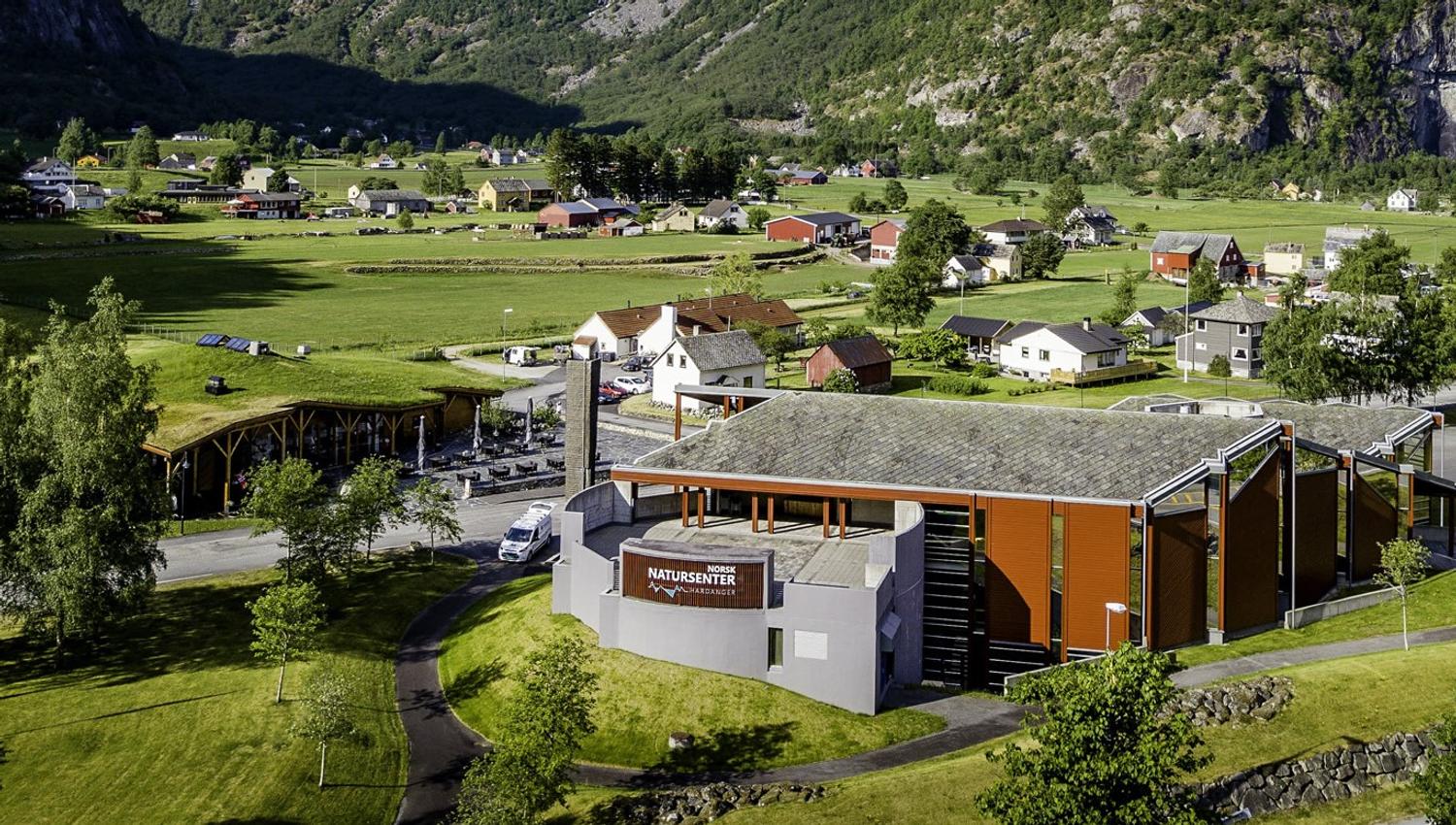 A drone photo of Norwegian Nature center with houses and farms in the background.