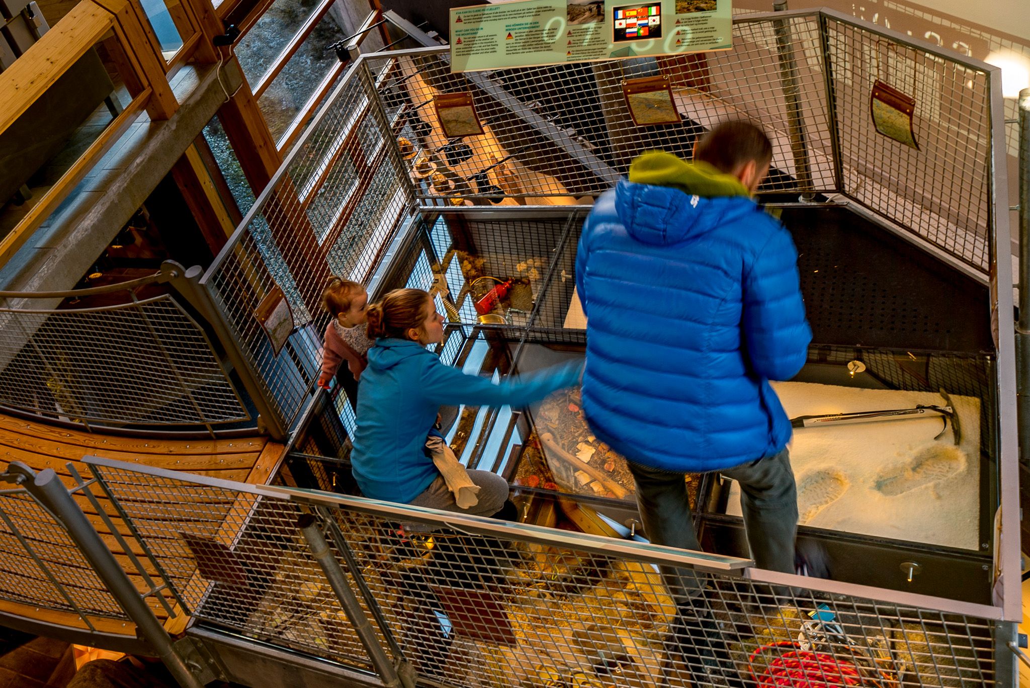 A family looks at parts of the exhibition that are mounted on the floor.