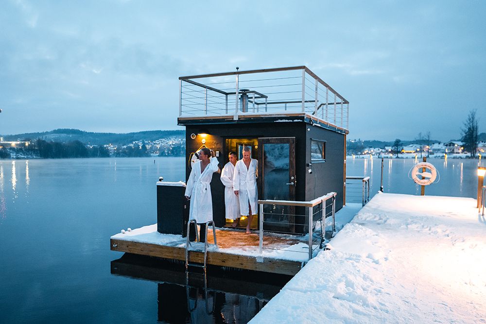 sauna på vannet med tre gjester i hvite badekåper