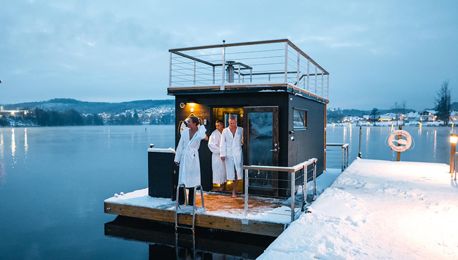sauna på vannet med tre gjester i hvite badekåper