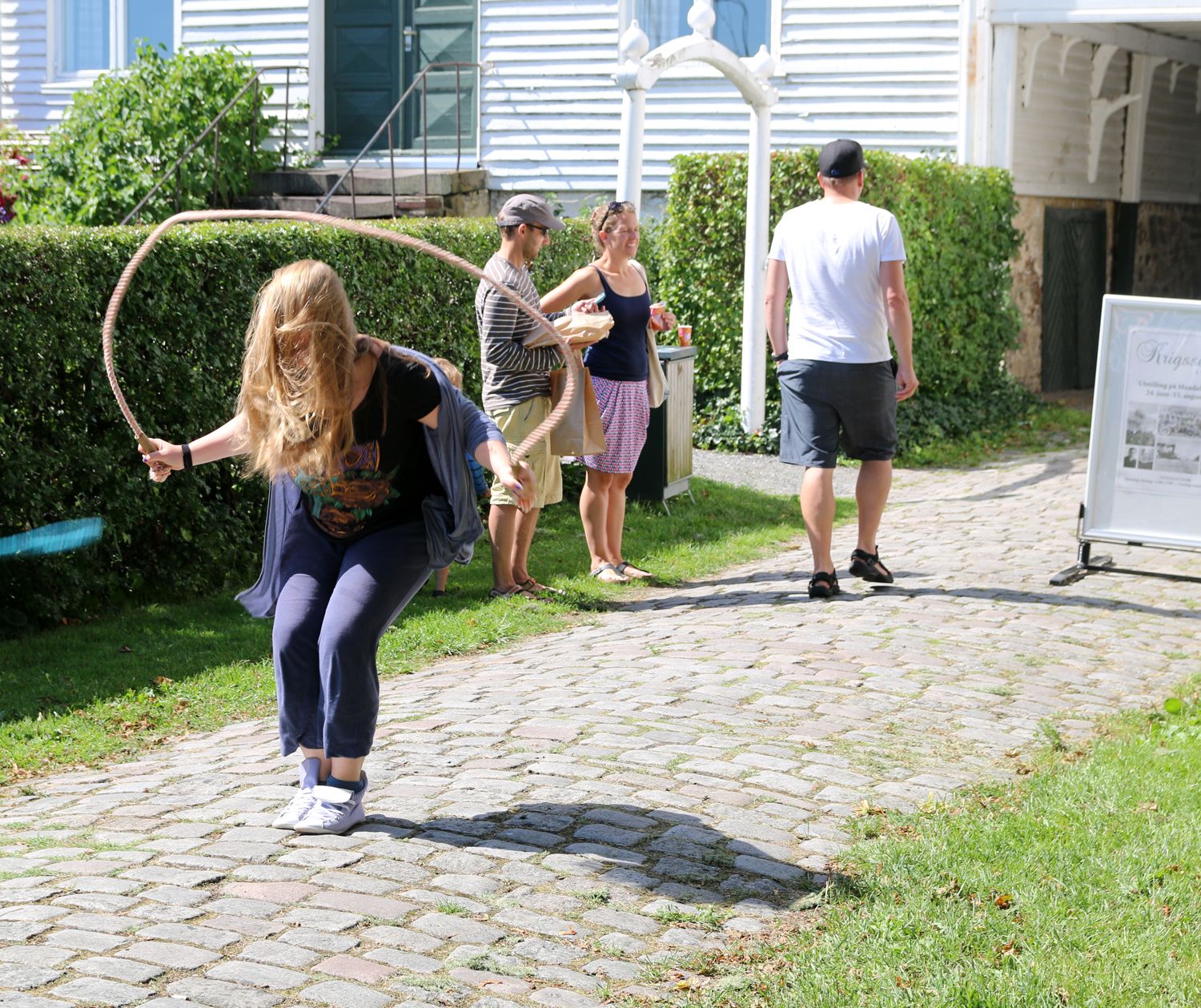 En jente som hopper i tau, og 3 andre i bakgrunnen og ser på noe annet