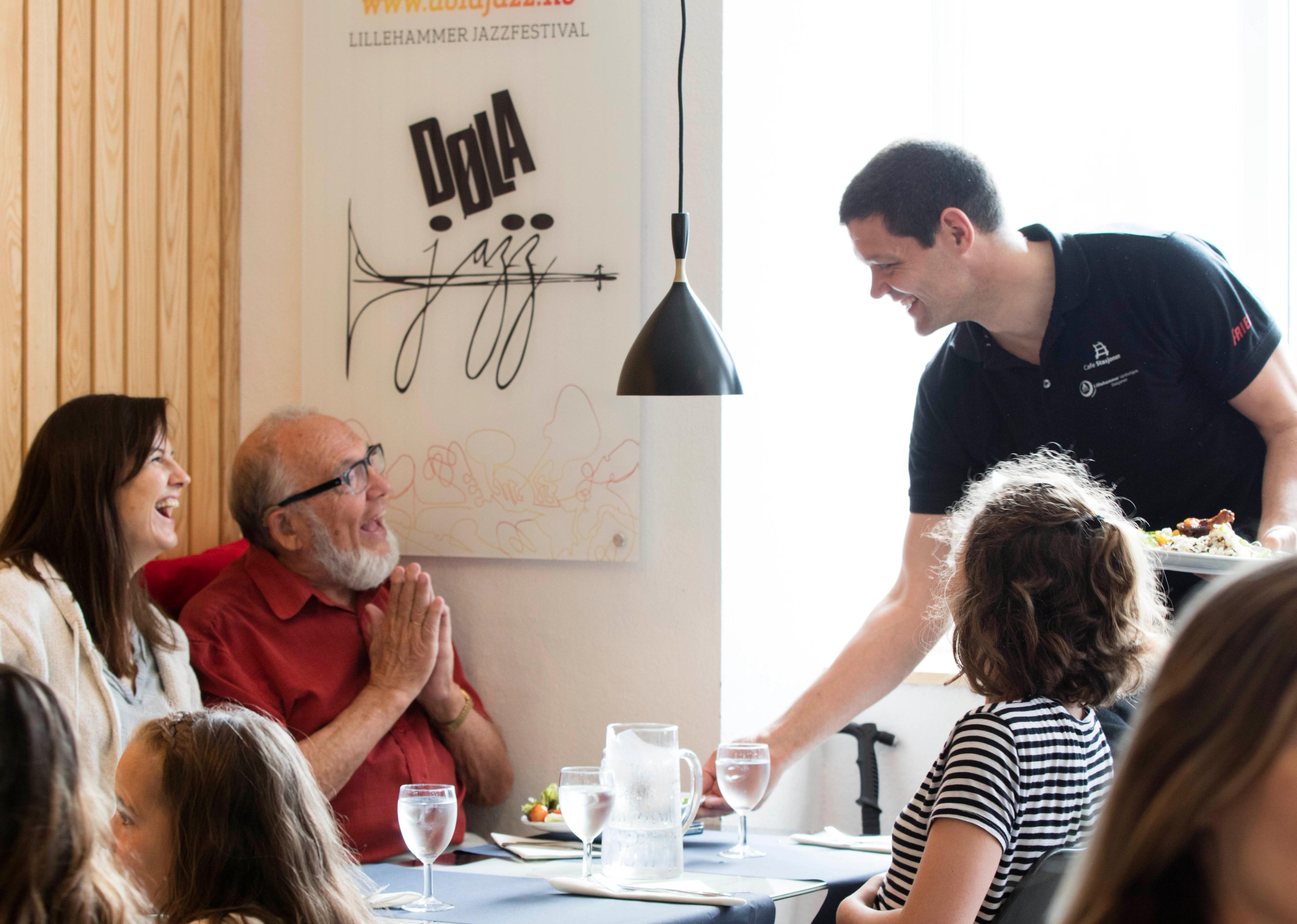 The host, Geir, serve guests at Stasjonen Cafe & Restaurant