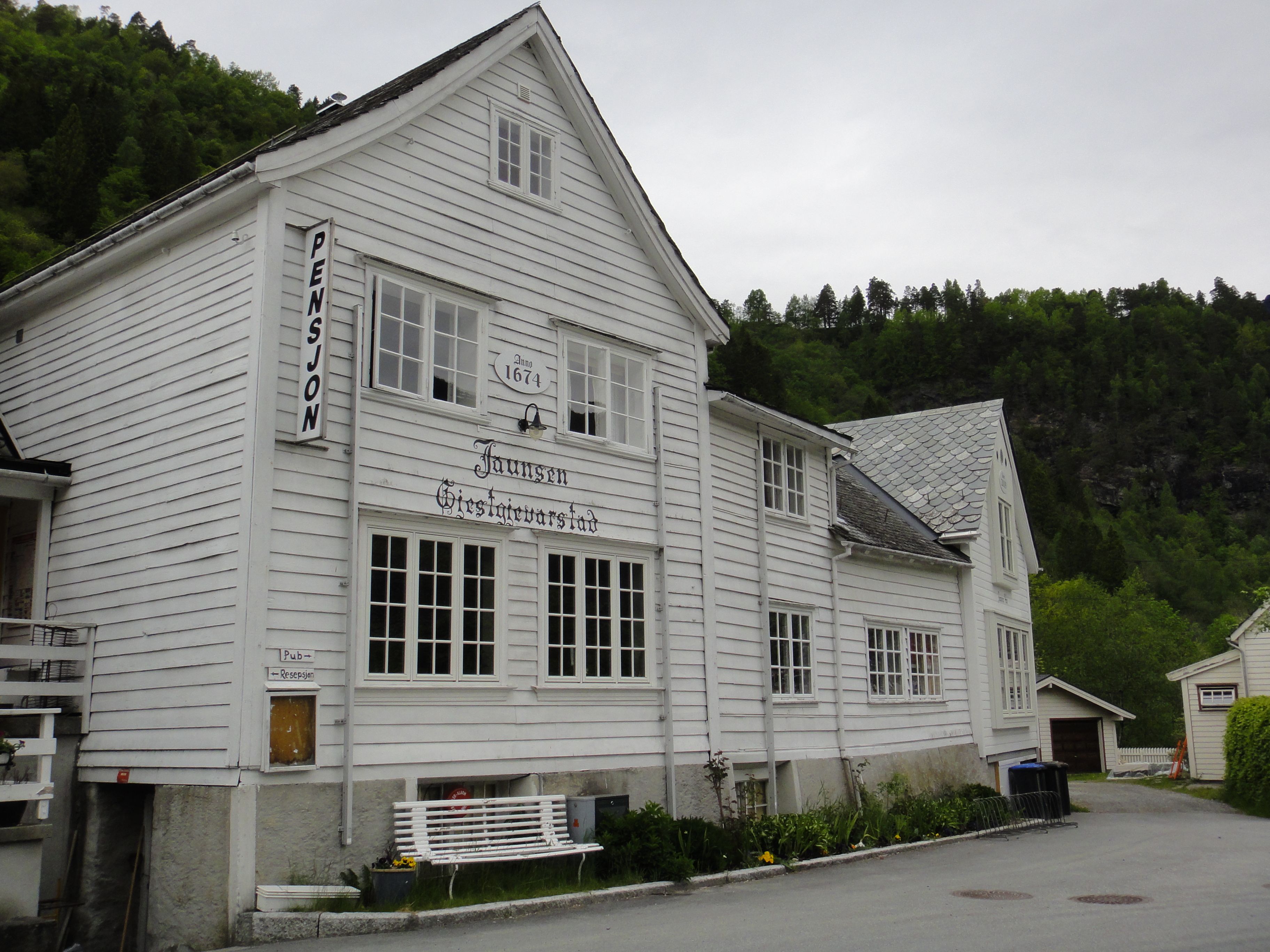 Den historiske fasaden til Jaunsen Gjestgjevarstad frå 1674, omgitt av vakker natur i Hardanger.