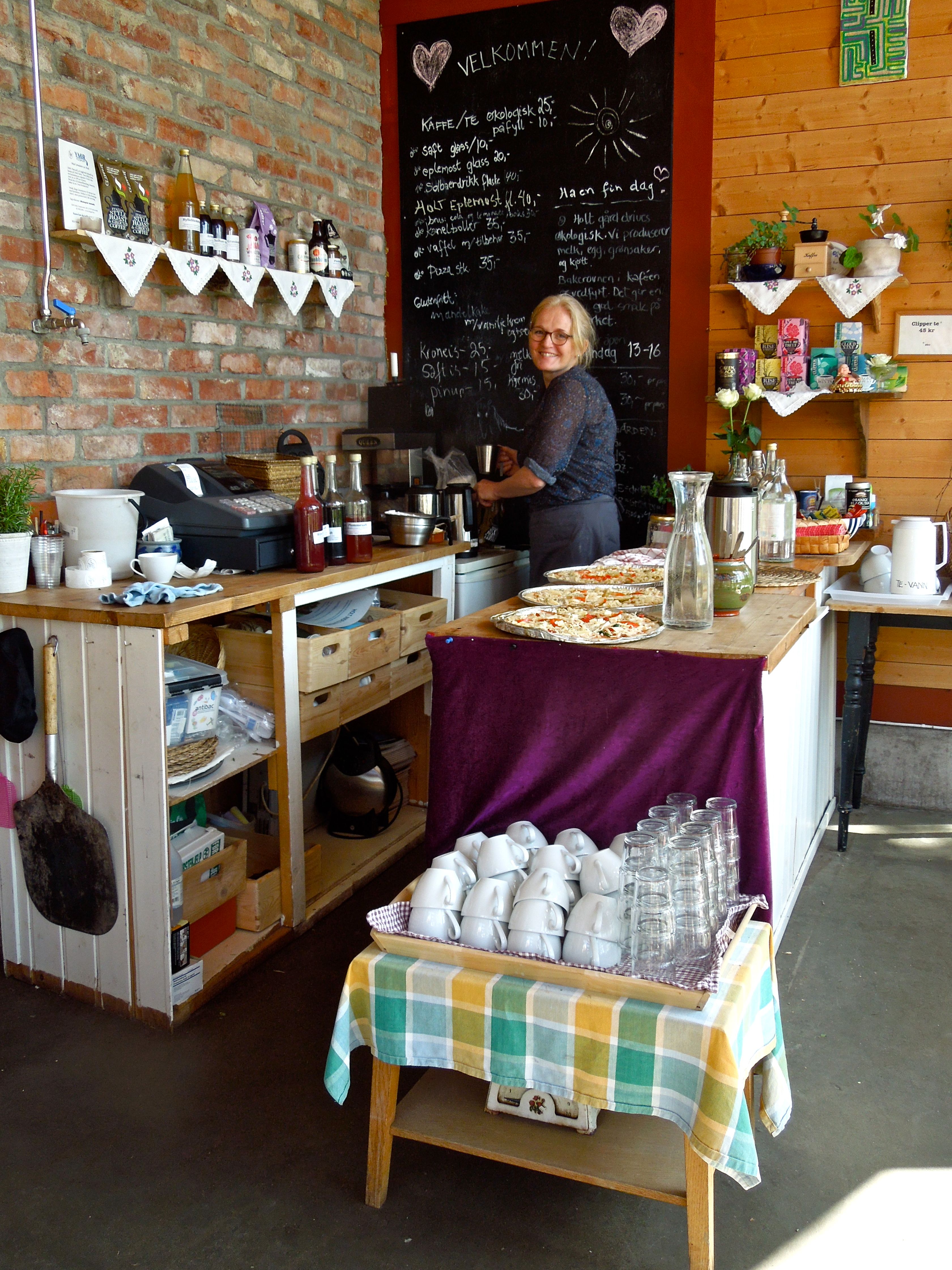 Inside Holt Gård cafe, with the smiling owner