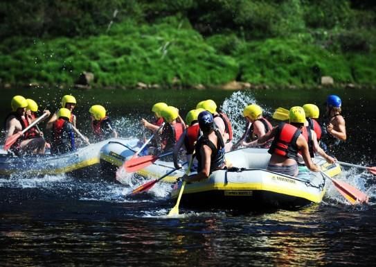 3 grupper med raftingflåter leker i vannet