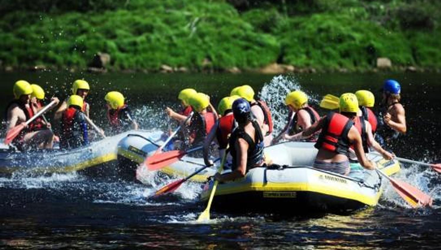3 grupper med raftingflåter leker i vannet