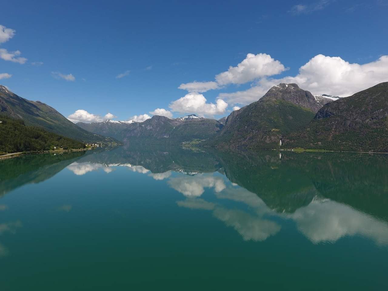 Utsikt frå Grande Camping over Oppstrynsvatnet og dei majestetiske fjella rundt Oppstryn i Nordfjord.