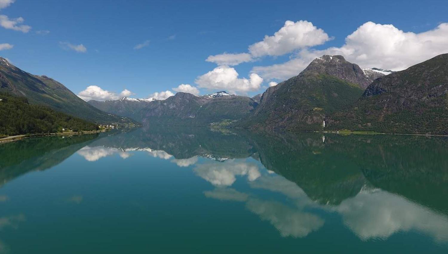 Utsikt frå Grande Camping over Oppstrynsvatnet og dei majestetiske fjella rundt Oppstryn i Nordfjord.