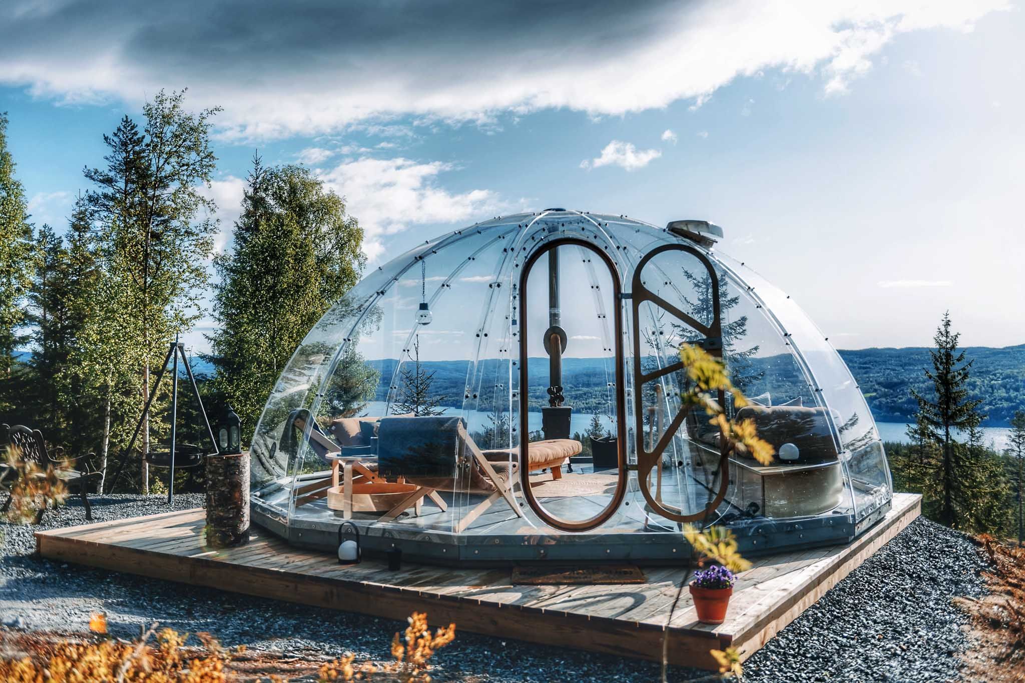 Glassiglo omgitt av trær med utsikt mot vannet