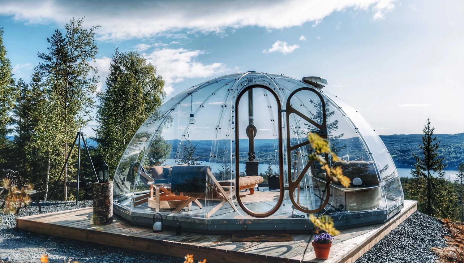 Glassiglo omgitt av trær med utsikt mot vannet