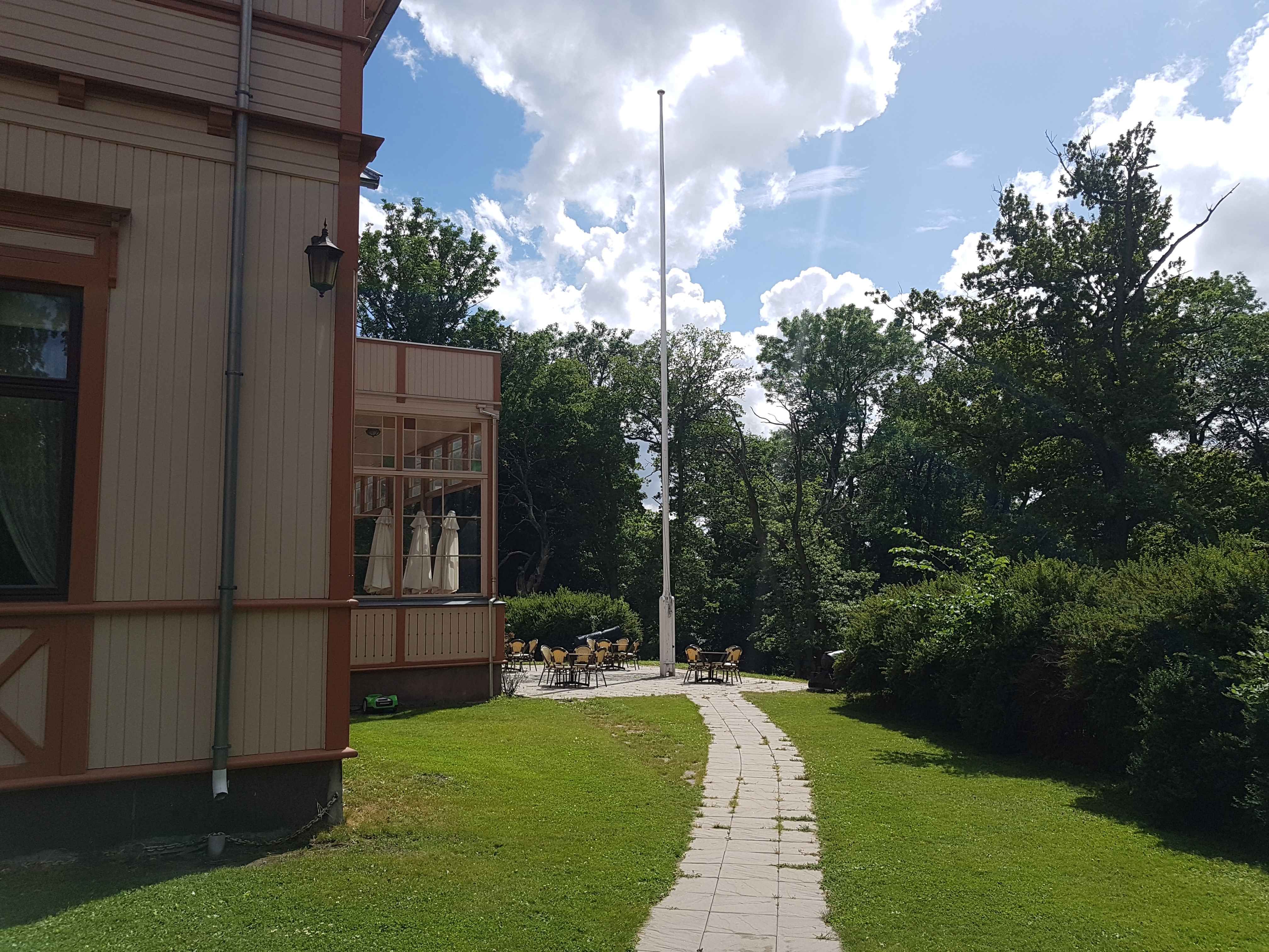 Storstuen, grønn plen og busker