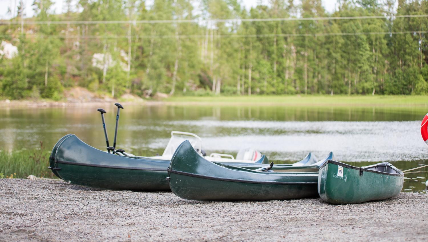 Tre kanoer på en strand