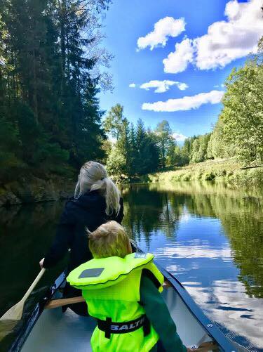 Child and adult paddling canoe
