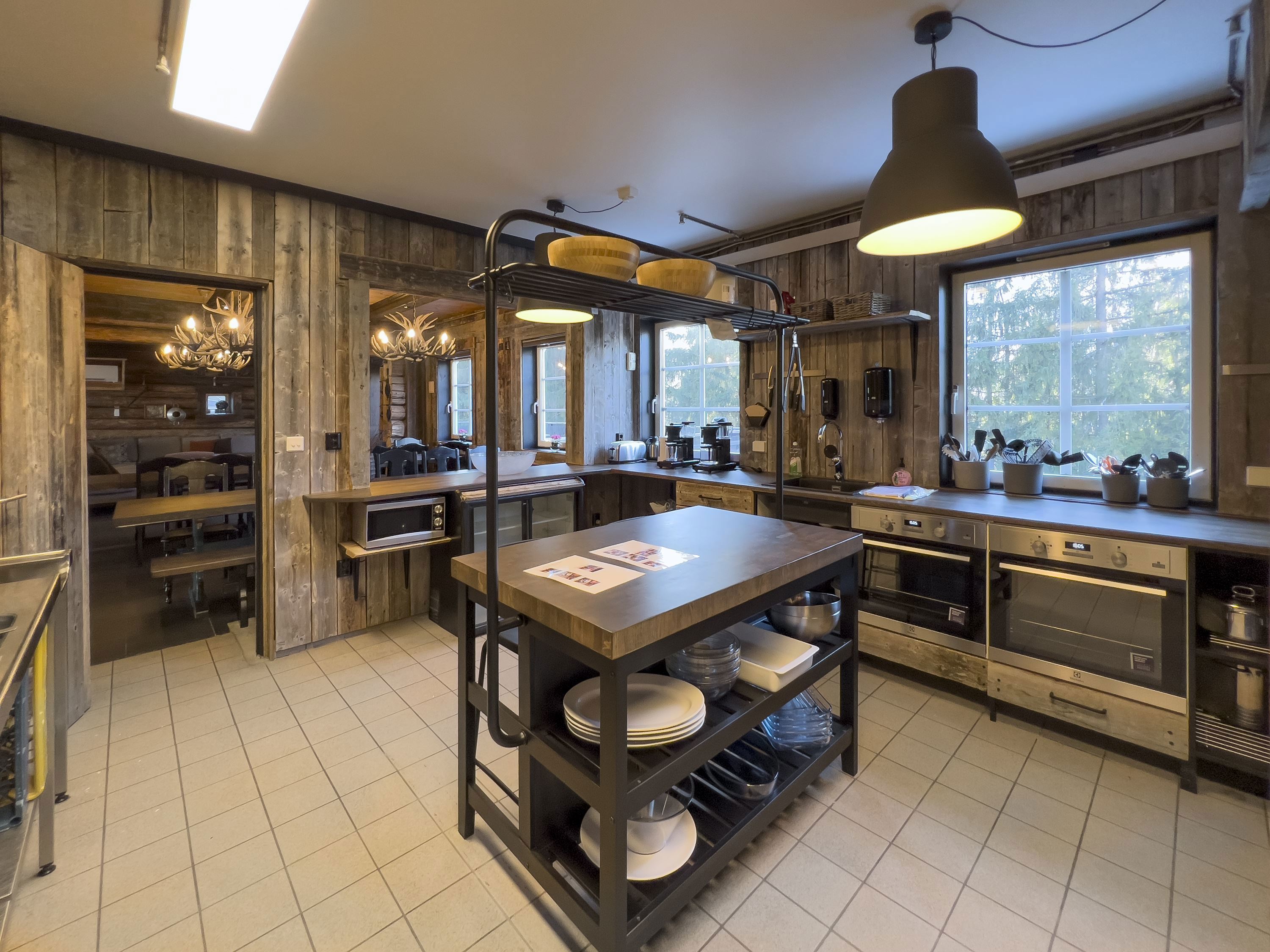 A kitchen with wooden walls and a large island.