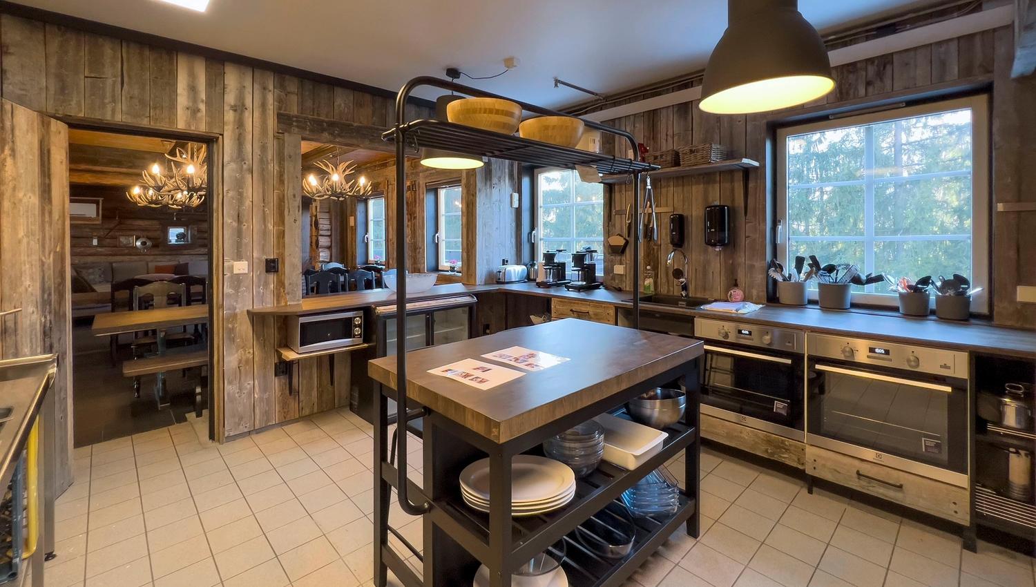 A kitchen with wooden walls and a large island.