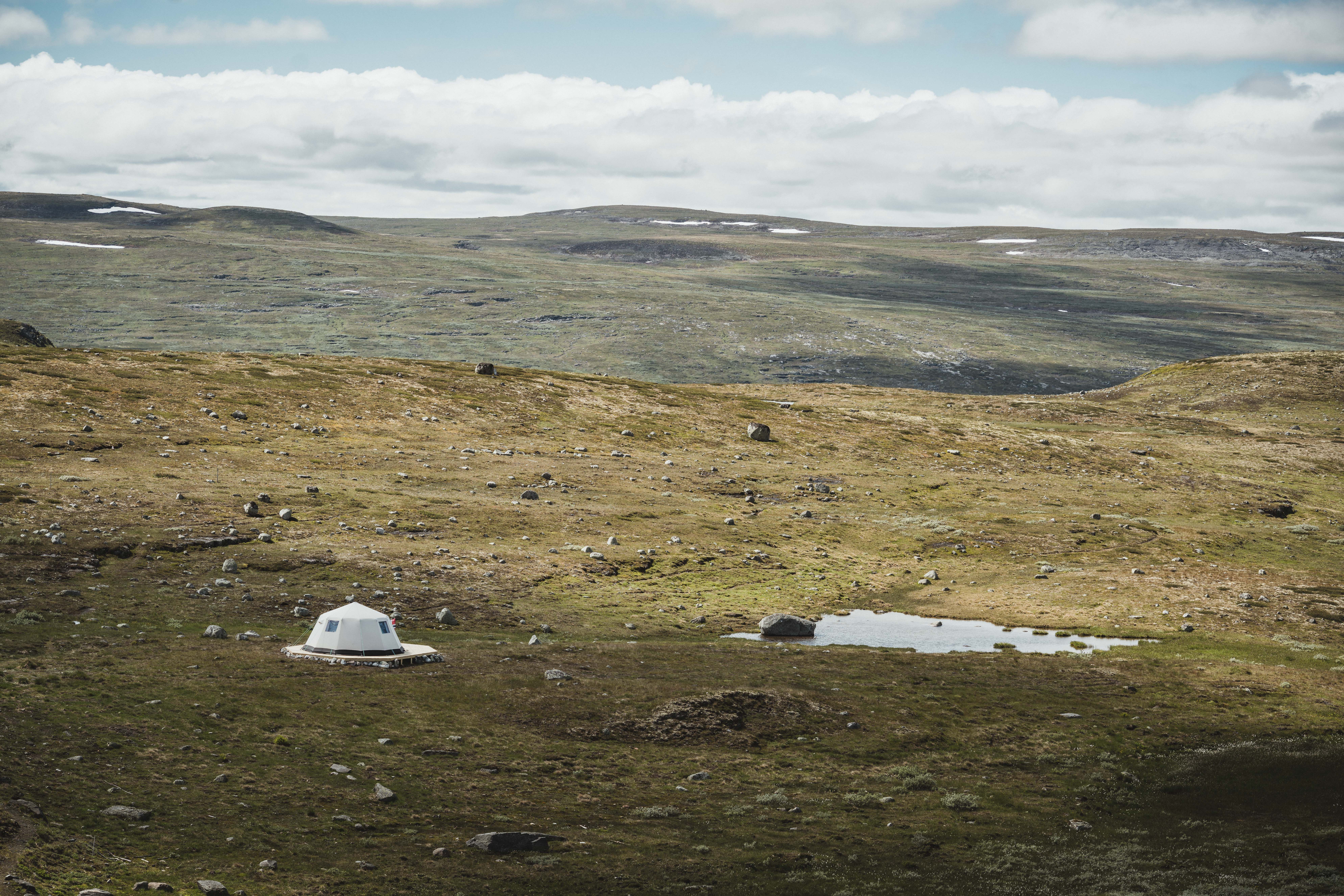 Et glampingtelt tilhørende Dyranut Fjellstova, satt opp rett ved et lite fjellvann.