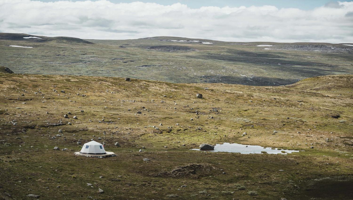Et glampingtelt tilhørende Dyranut Fjellstova, satt opp rett ved et lite fjellvann.