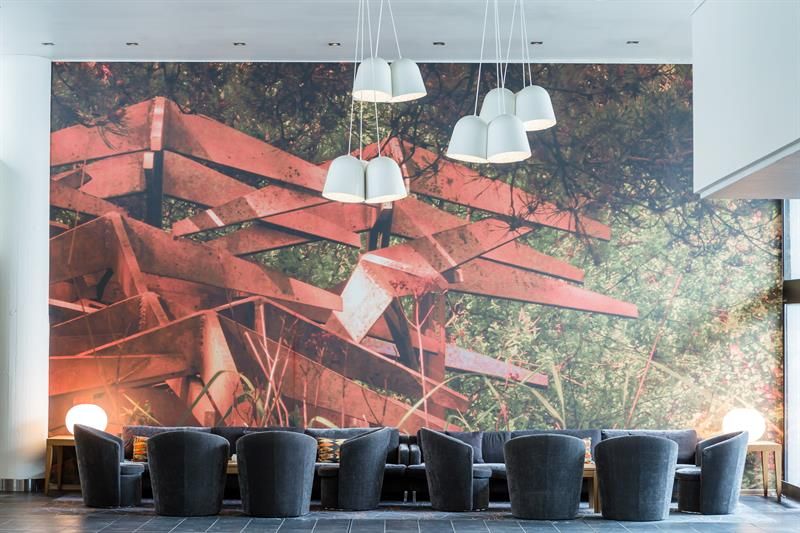 Kunstnerisk veggdekor med røde takmotiv i et stilfullt møterom eller loungeområ