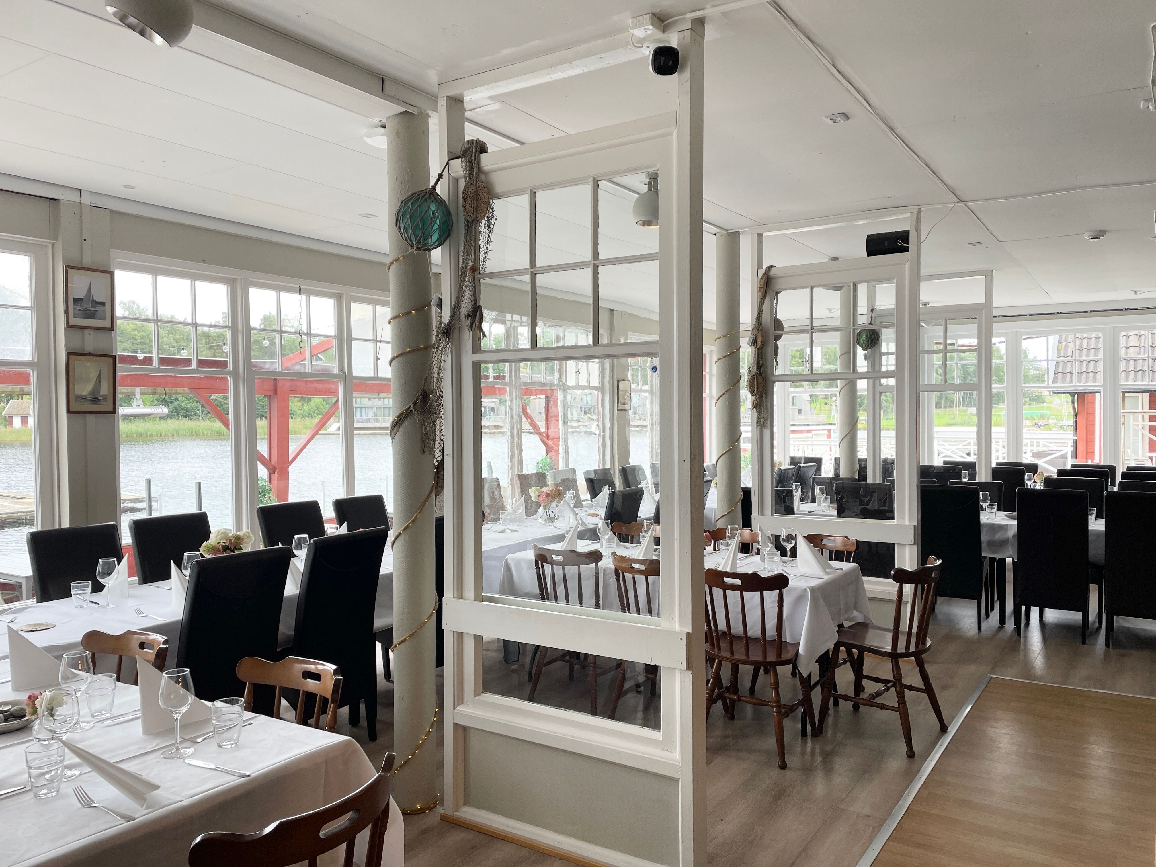 Hankø Seilerkro set for dinner, with large windows offering a sea view.