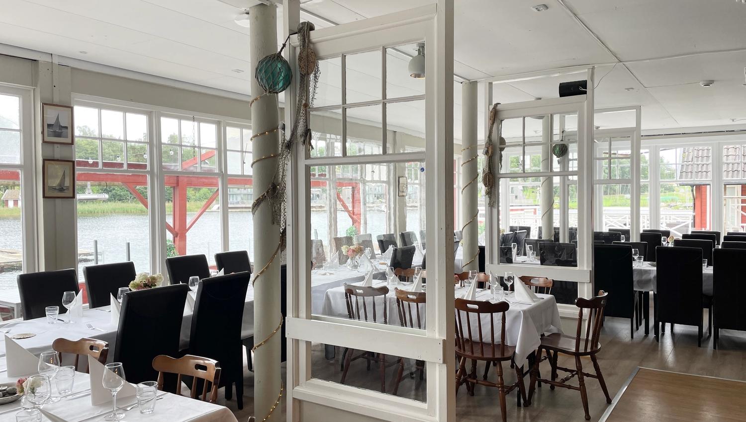 Hankø Seilerkro set for dinner, with large windows offering a sea view.