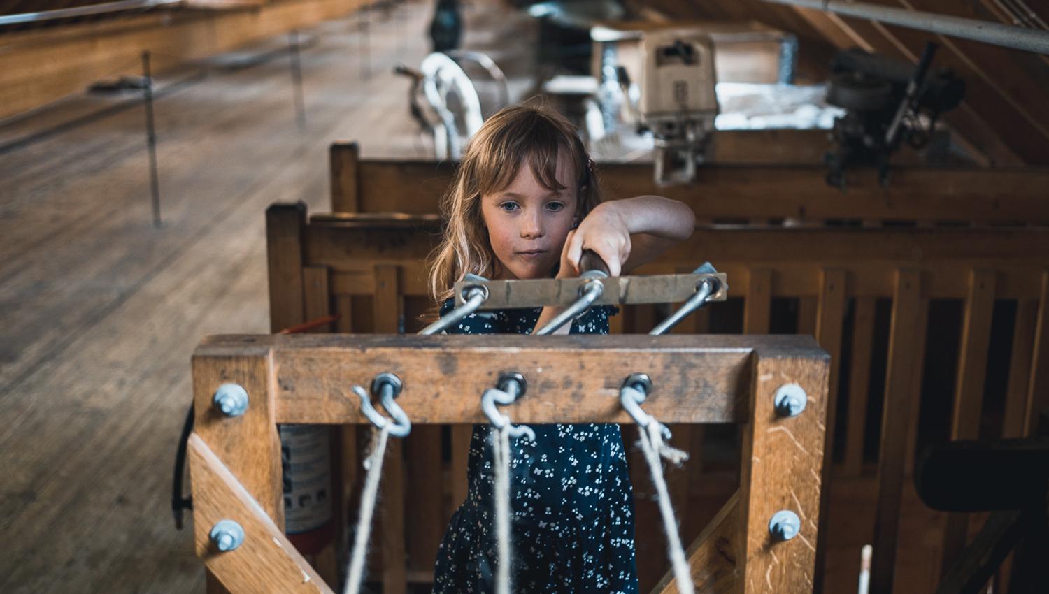 A girl testing out old ship equipment at Hardanger Maritime Center.