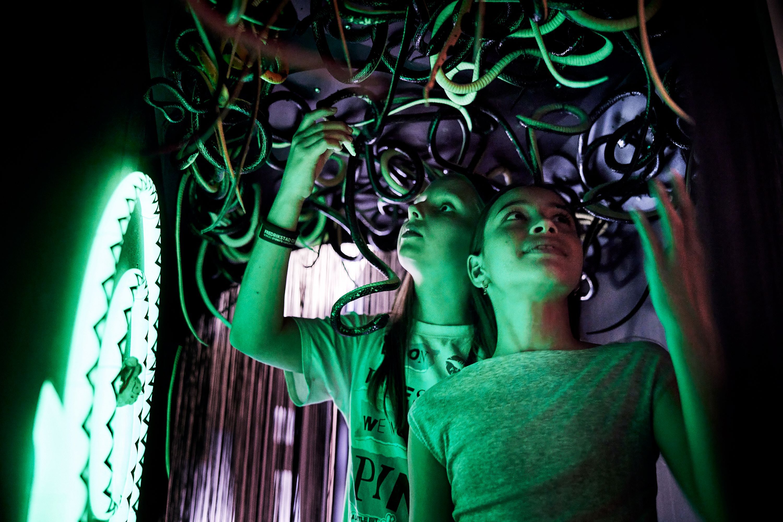 Two children with plastic snakes hanging above their heads