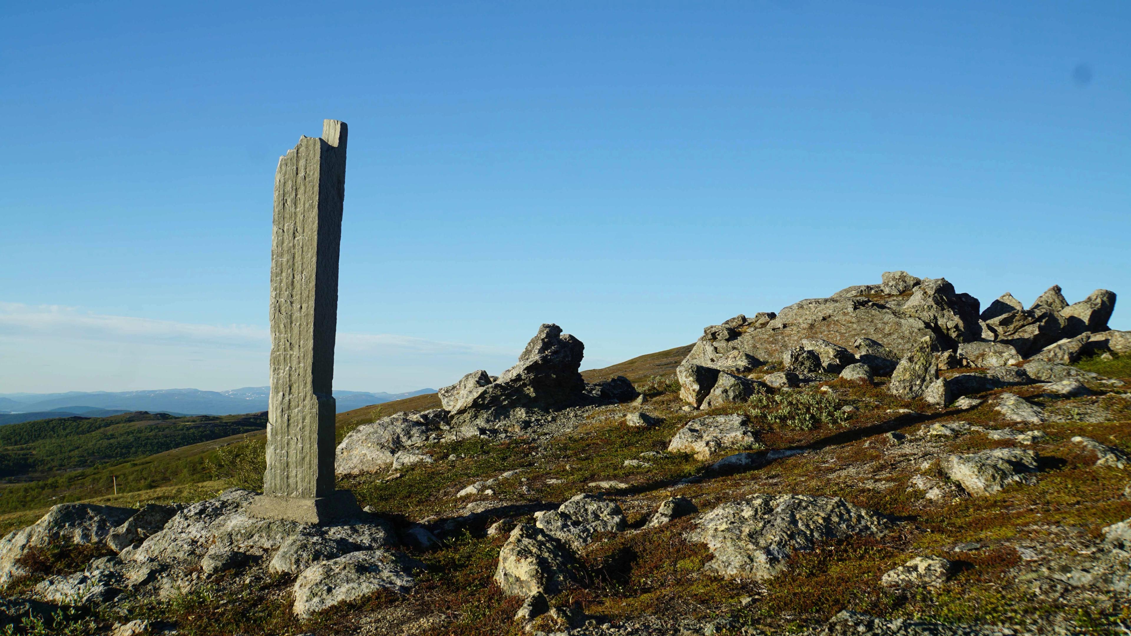 Bilde av nasjonalparkbauta ved Lierne Nasjonalpark. Blå himmel.