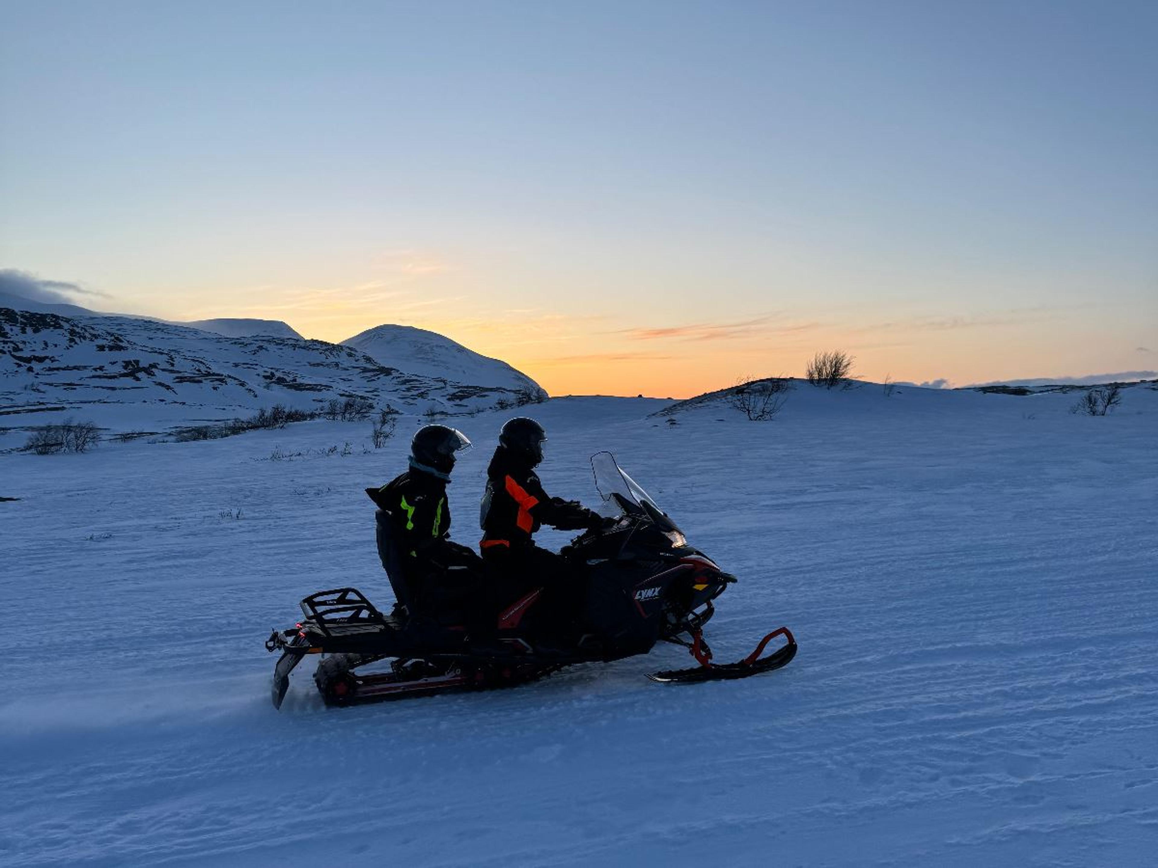 Two guests on a snowmobile