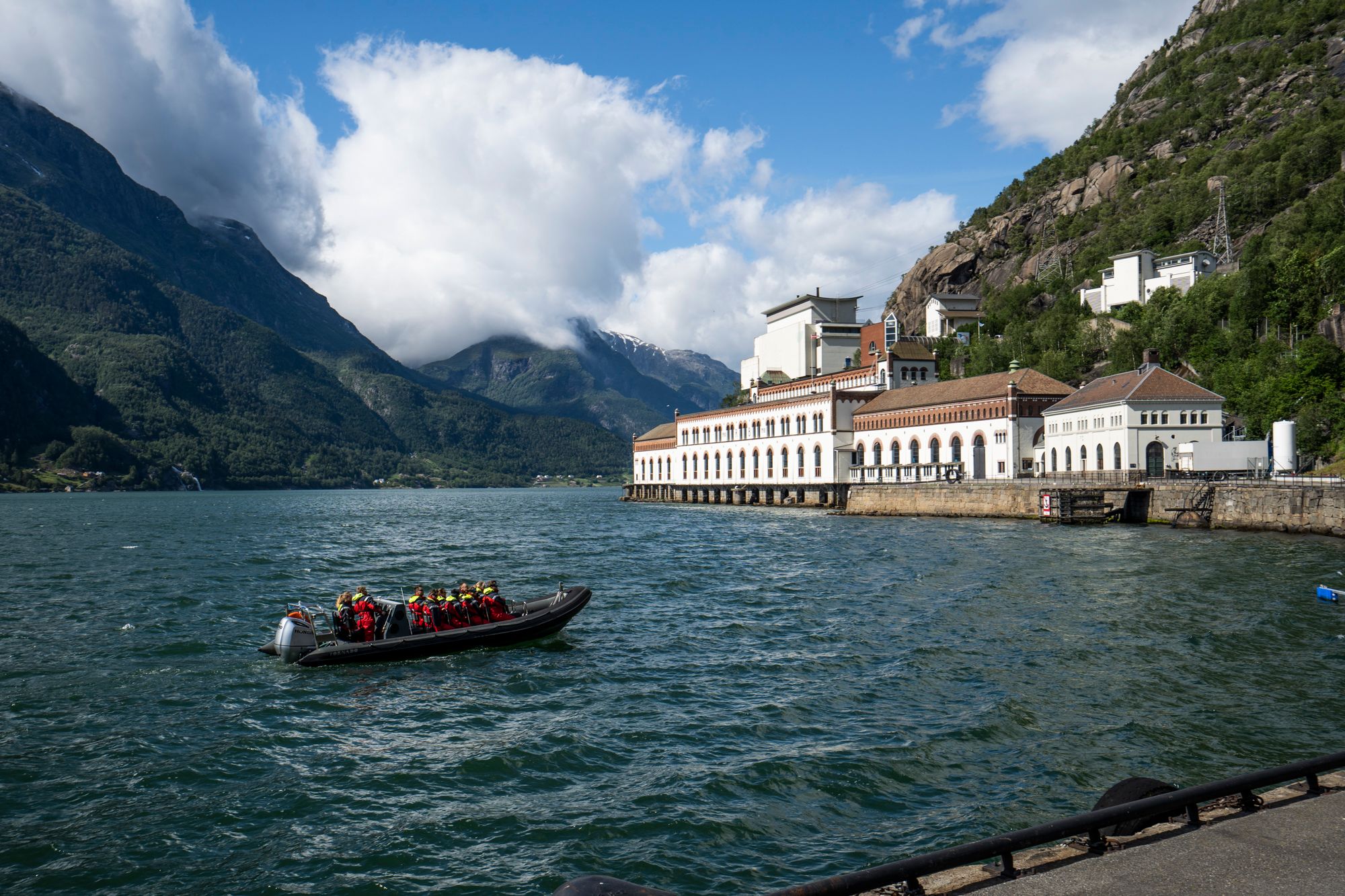 A RIB boat by an iconic industrial heritage building along the Hardangerfjord.